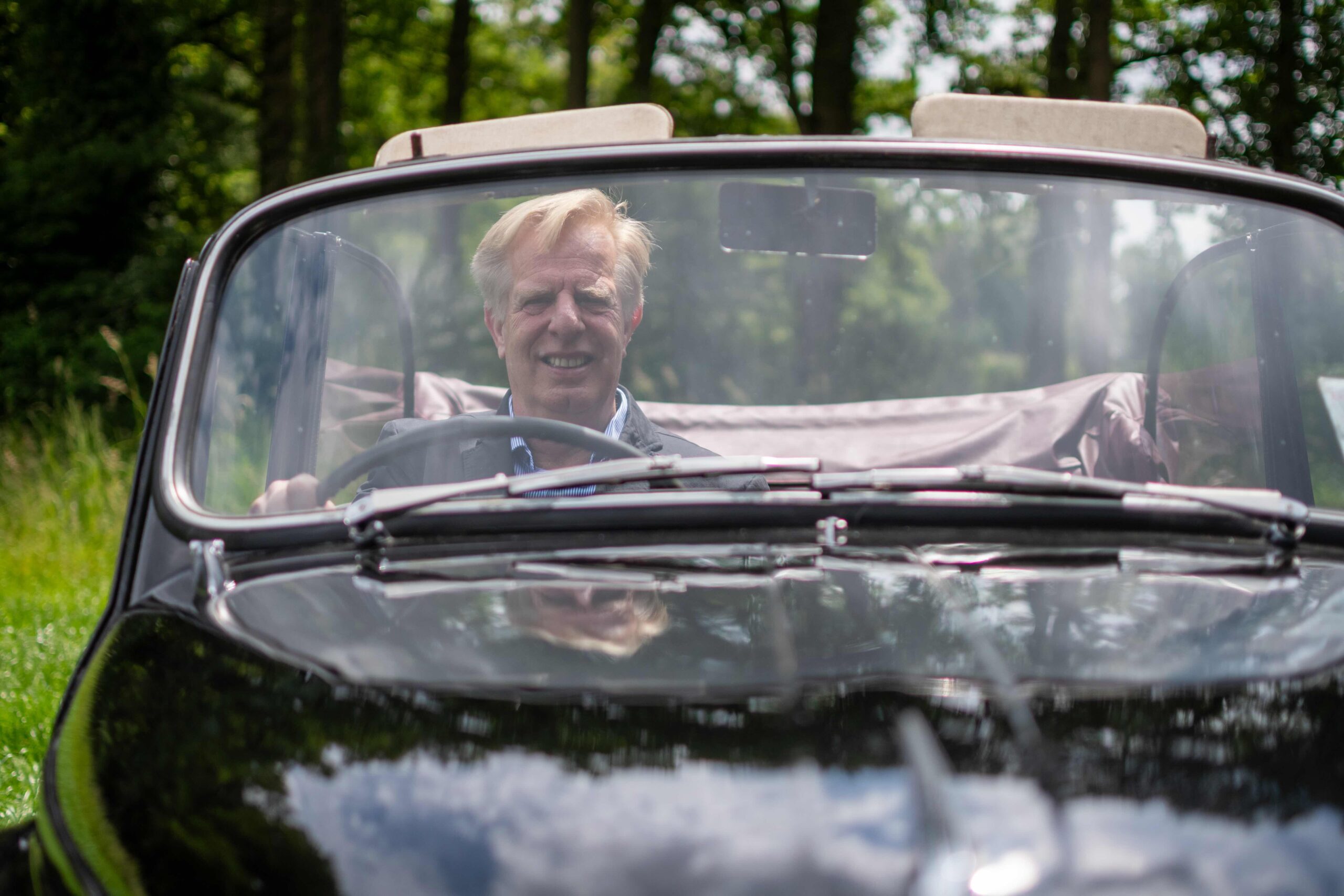 Chauffeur achter het stuur van de Morris Minor